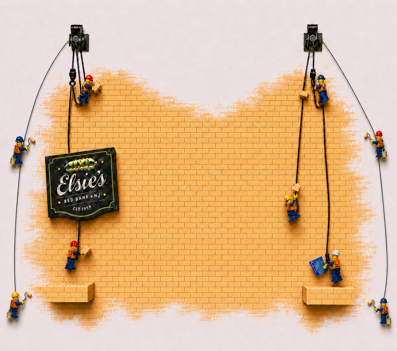 Elsie's construction wall design with miniature builders and yellow brickwork