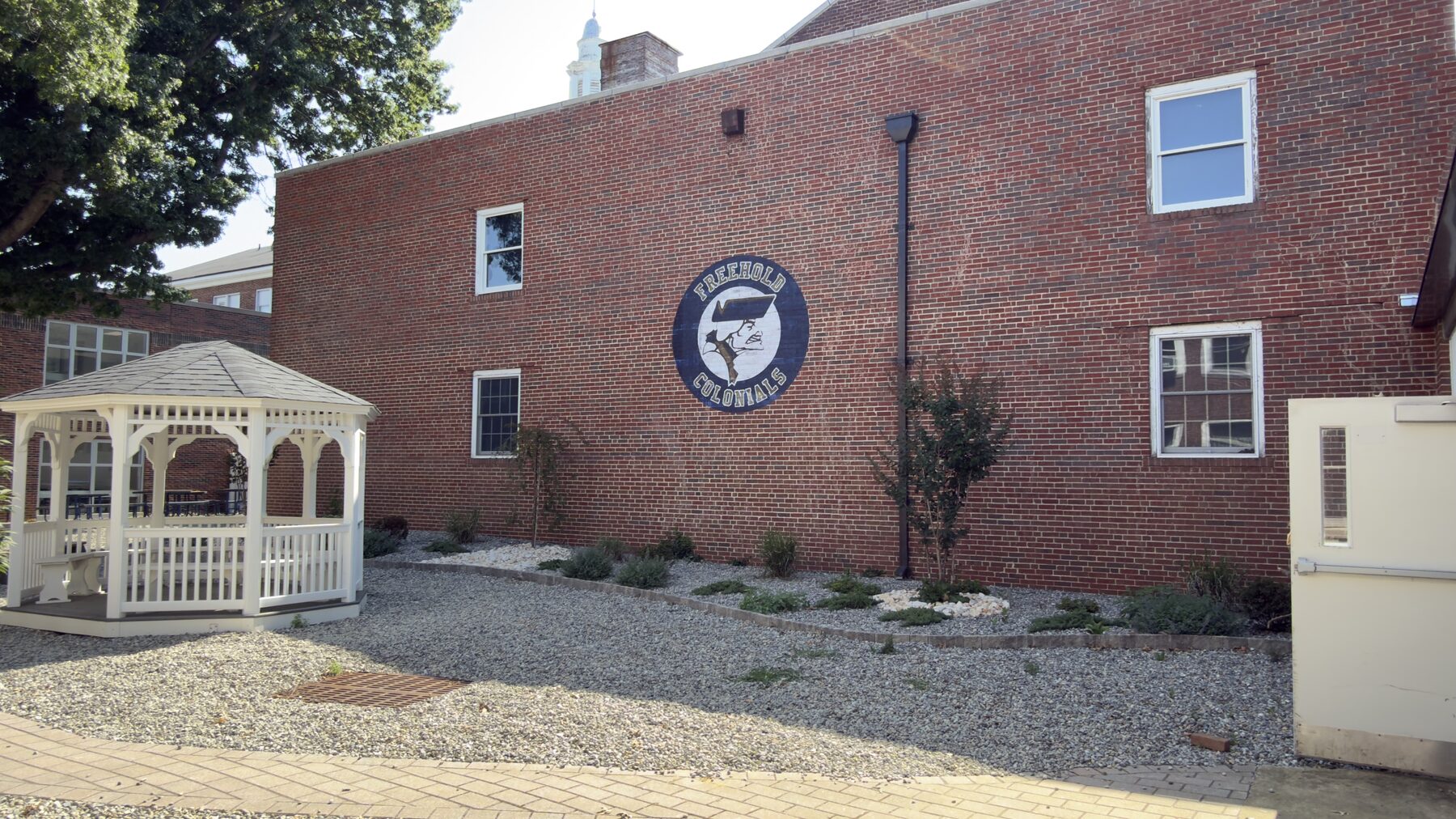 Wide finished view of the Freehold Colonials wall print and surrounding school café courtyard