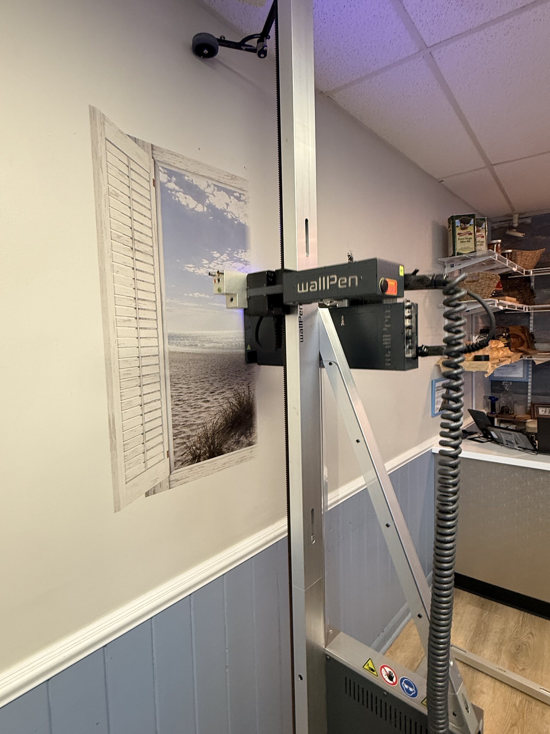 UAF's wall printer aligned on site with the shuttered coastal-window scene at Krust Cafe